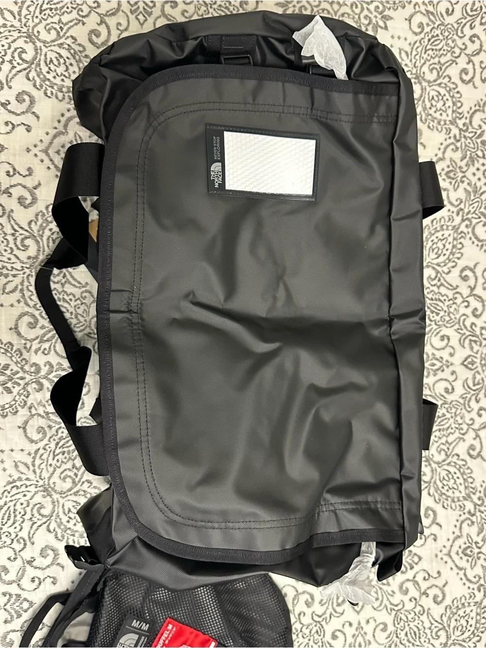 The North Face Base Camp Duffel M in Black with Red Tag